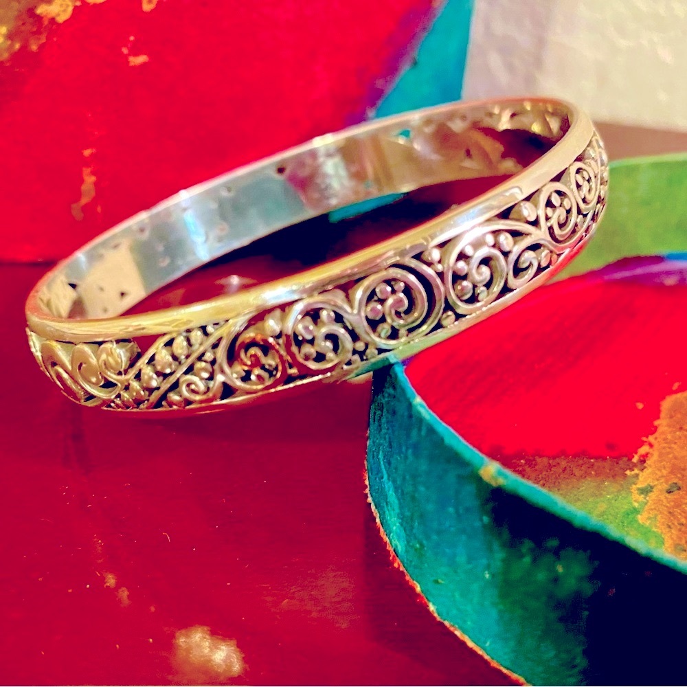 Silver bangle bracelet with ornament inlay design.